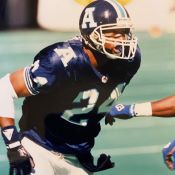 Un joueur de football en uniforme bleu courant sur le terrain.