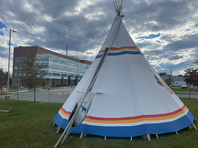 Un tipi de la GRC trône dans la cour de la Direction générale de la GRC en Nouvelle-Écosse devant une tour à bureaux.