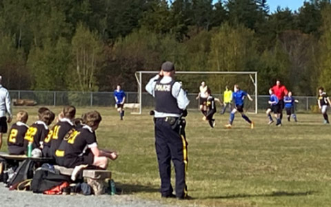 Shawn Galbraith se tient debout sur le bord d'un terrain de football en uniforme.