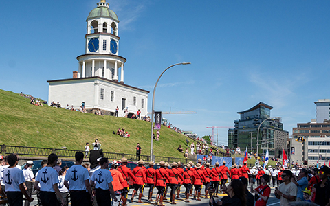 A group of RCMP officers in red serge march below Citadel Hill.