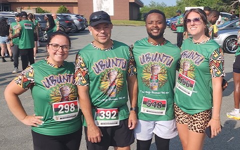 Four runners in their running gear pose for a photo.