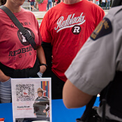 Un membre de la GRC parle avec deux personnes portant des vêtements du ROUGE et NOIR d'Ottawa.
