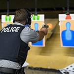 Cadets shoot at targets with their pistols at close range.