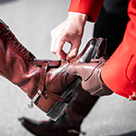 Un cadet en aide un autre à ajuster une botte.