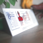 Un(e) membre en tunique rouge place une carte du Programme des partenaires silencieux sur une table.