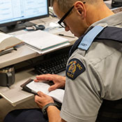 A cadet wearing glasses looks through their note pad.