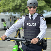 Chief Superintendent Dave Chauhan riding an e-scooter