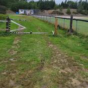 A photo of the damaged fence. The baseball diamond can be seen in the background.
