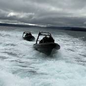 Two RCMP Zodiac vessels are on the water following one another.