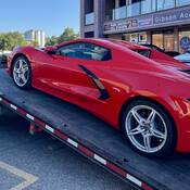 A red Corvette in the process of being loaded onto a tow truck in Coldstream, BC