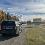 A BC Highway Patrol ghost cruiser with its emergency lights on in front of a construction zone sign on Highway #97 near Prince George