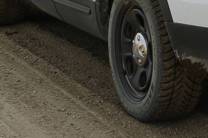 Car tire on gravel road.