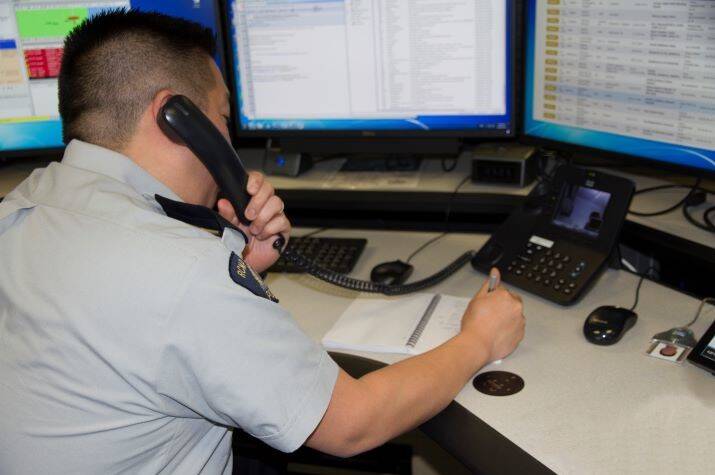 Male police officer sitting while speaking on the phone.