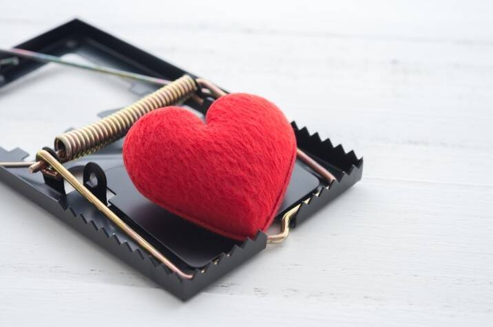 A small, red heart-shaped cushion in a mouse trap.