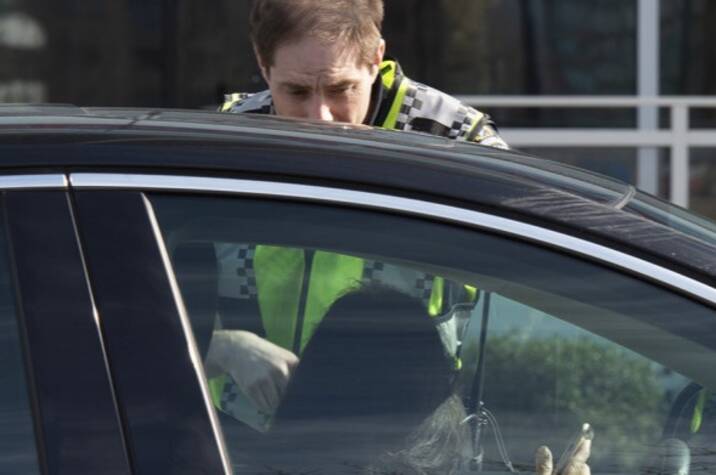 Police officer speaking to the driver of a car.