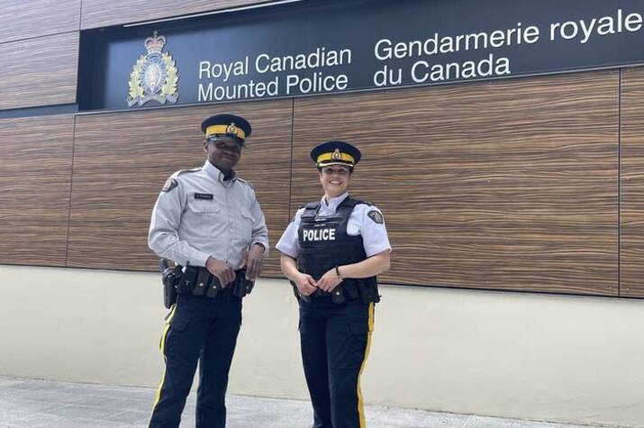 Officers stand in the from of a building
