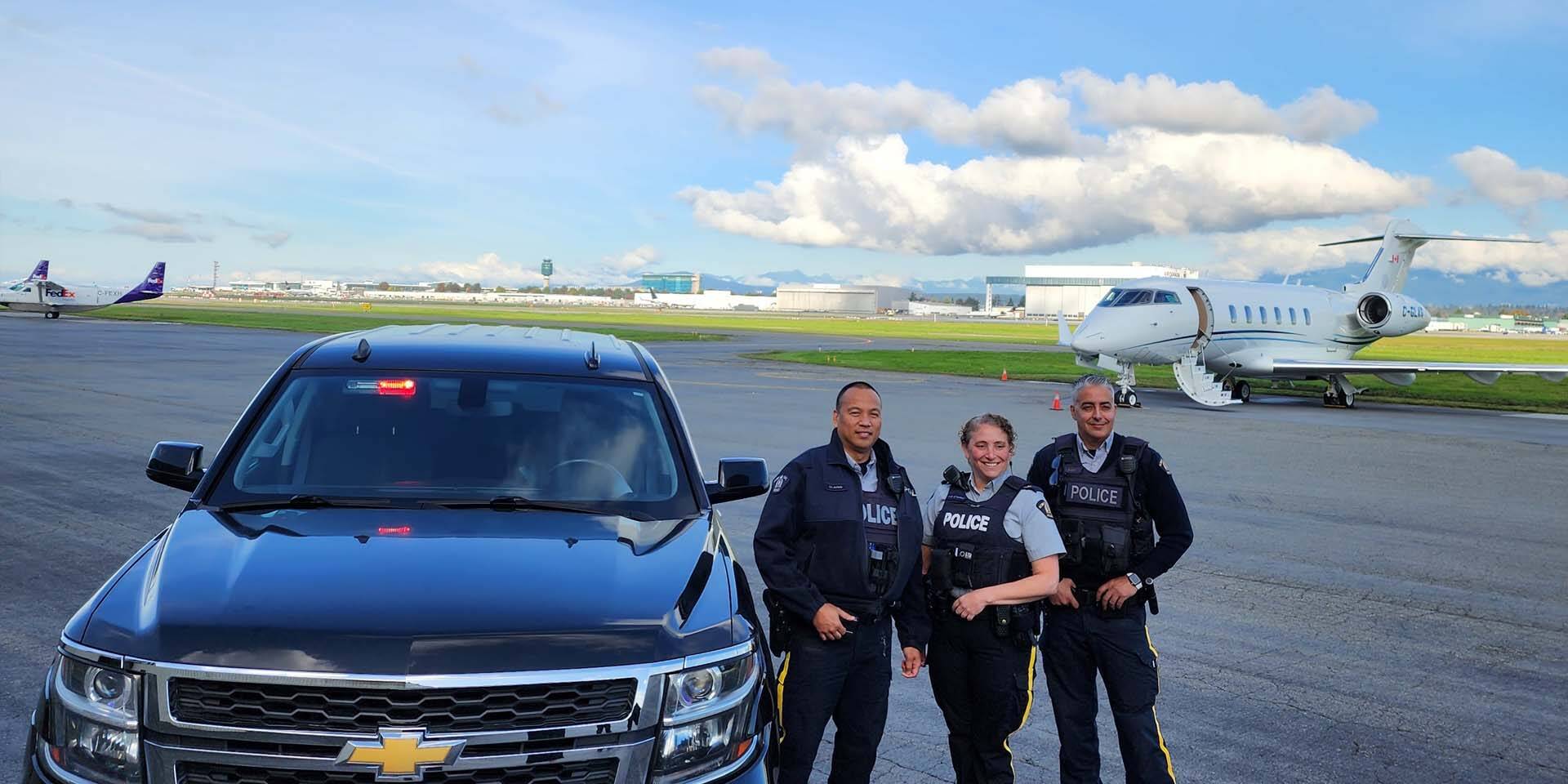 Richmond RCMP officers standing by truck and planes