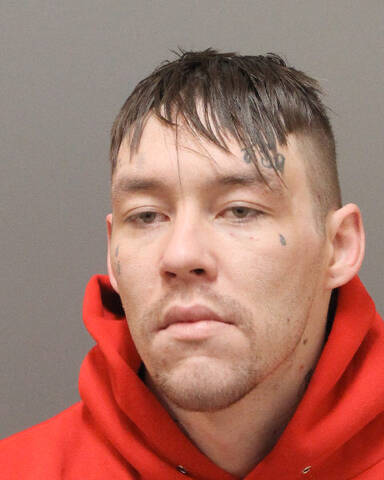 Male with green eyes, brown hair, and multiple face tattoos. | Un homme aux yeux verts, aux cheveux bruns et portant plusieurs tatouages sur le visage.