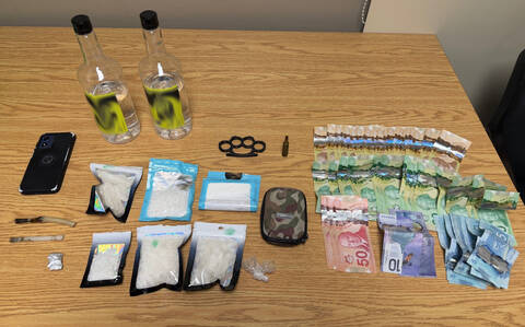 A photo of drugs, cell phones, alcohol, cash and other paraphernalia.