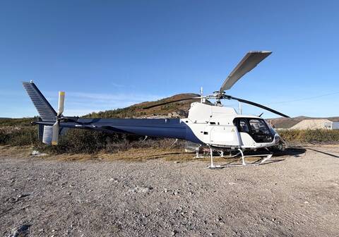 A blue and white helicopter on the ground.
