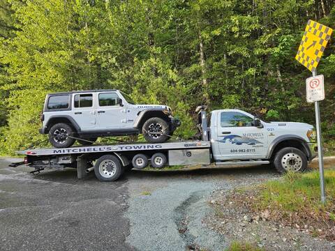 Thumbnail image: This white Jeep was impounded for excessive speeding and impaired driving and is seen here on the back of a tow truck at the side of Highway #99