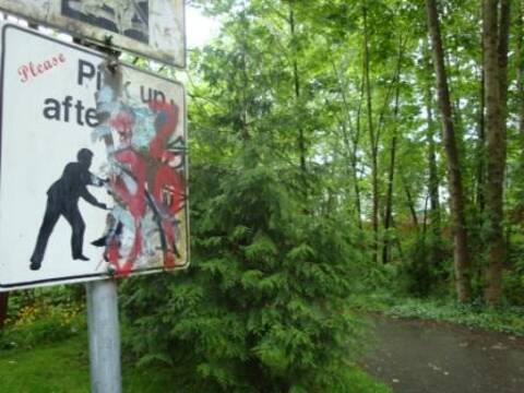 A park sign with graffiti